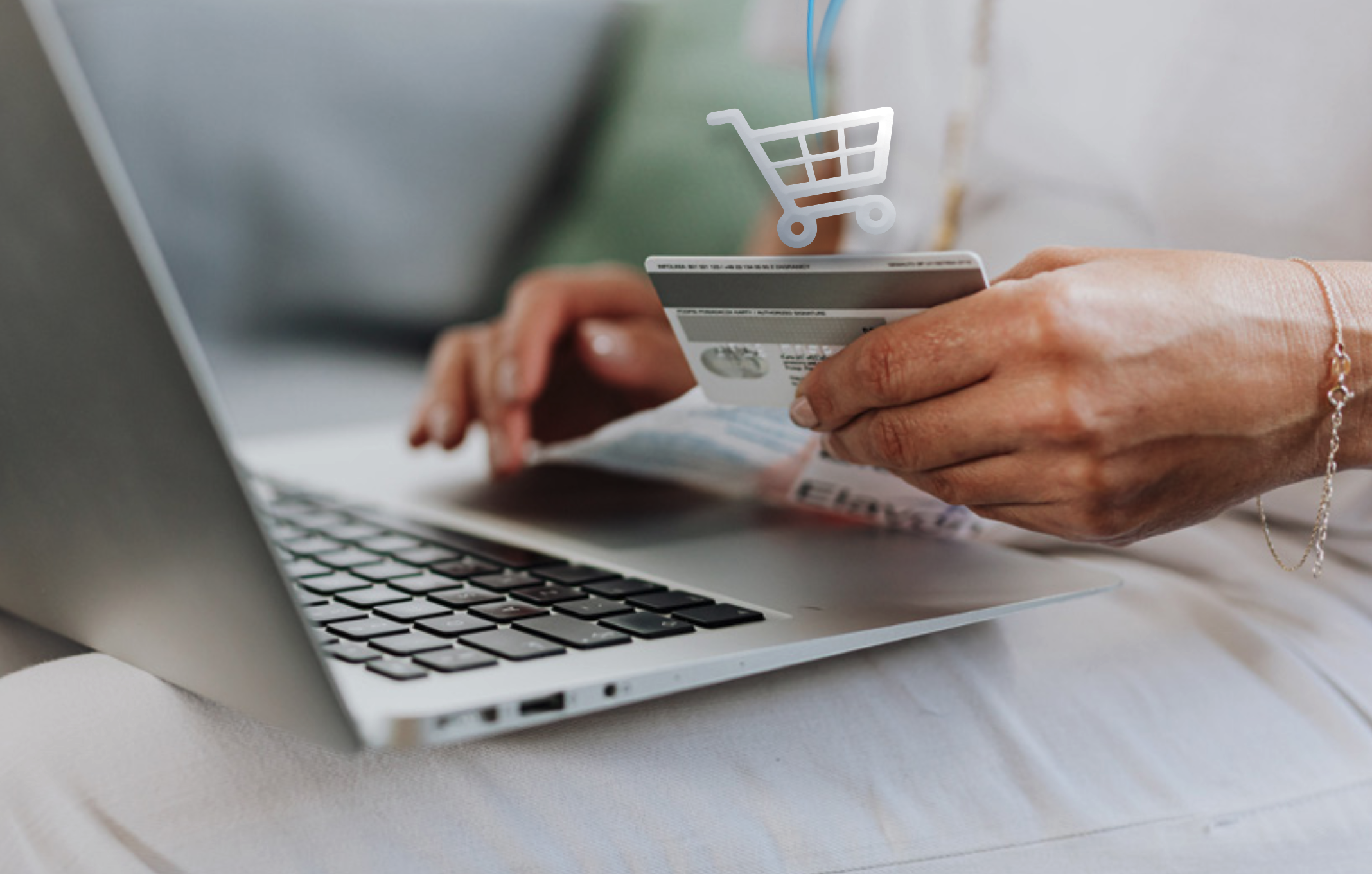 Close-up of a person using a laptop and holding a credit card, symbolising e-commerce and logistics, online shopping, and digital transactions with a shopping cart icon overlay